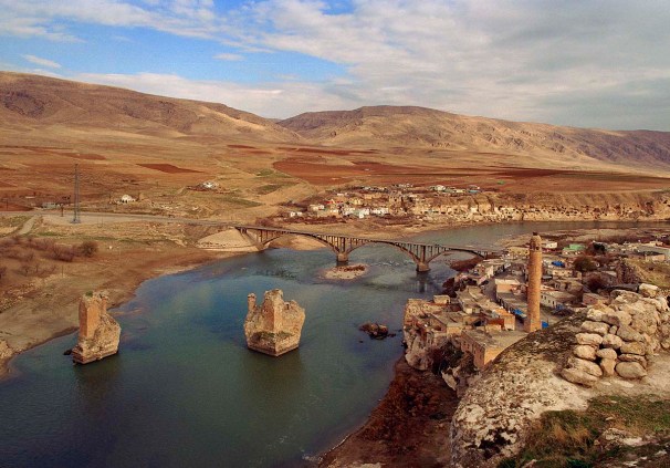 Hasankeyf a view from the ancien town to the river Tigris and the bridge. Photo 4. July 2007. Blick auf die alte Stadt und die Bruecke Seidenstrasse ueber den Tigris. Im Hintergrund und rechts sind die Felsen voll von Wohnhoehlen.